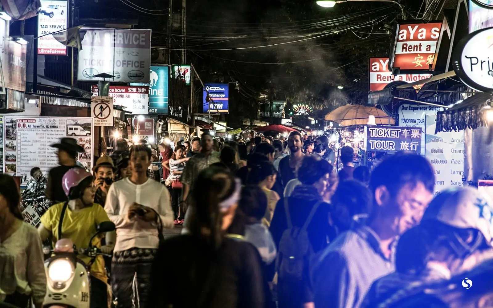 ถนนตลาดกลางคืนที่มีคนเดินและป้ายไฟ